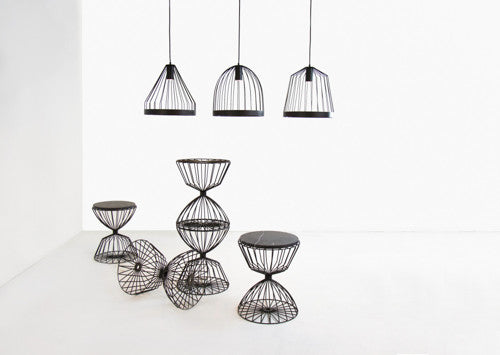 Hanging bird cage lamps above metal and marble tables. 