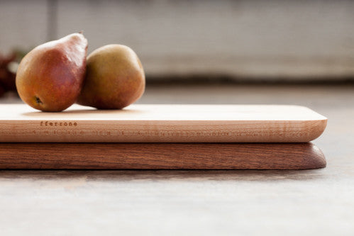 Maple side up on a rectangular cutting board composed of walnut and maple, styled with two pears. 