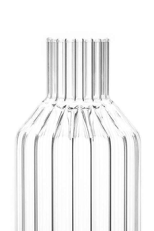A close-up of a designer decanter in fluted glass without lid on. 